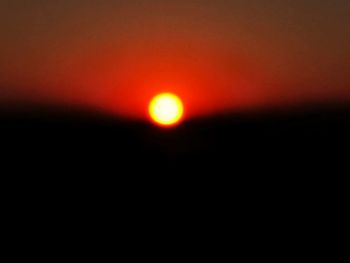 Defocused image of silhouette landscape against sky during sunset