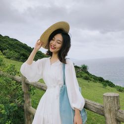 Woman standing by sea against sky