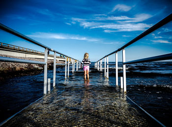 Bridge over river against cloudy sky