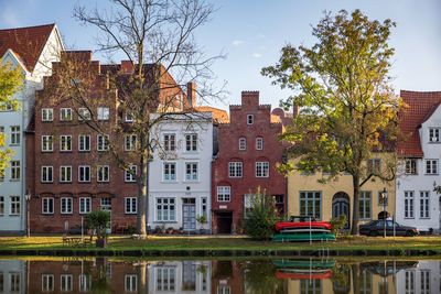 Residential buildings by canal against sky