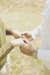 Midsection of couple holding hands