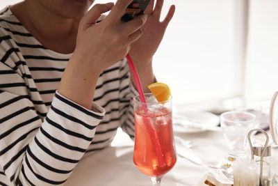 Cropped image of woman holding drink