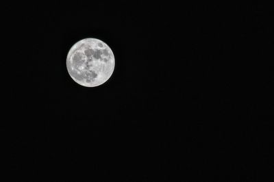 Low angle view of full moon against clear sky at night