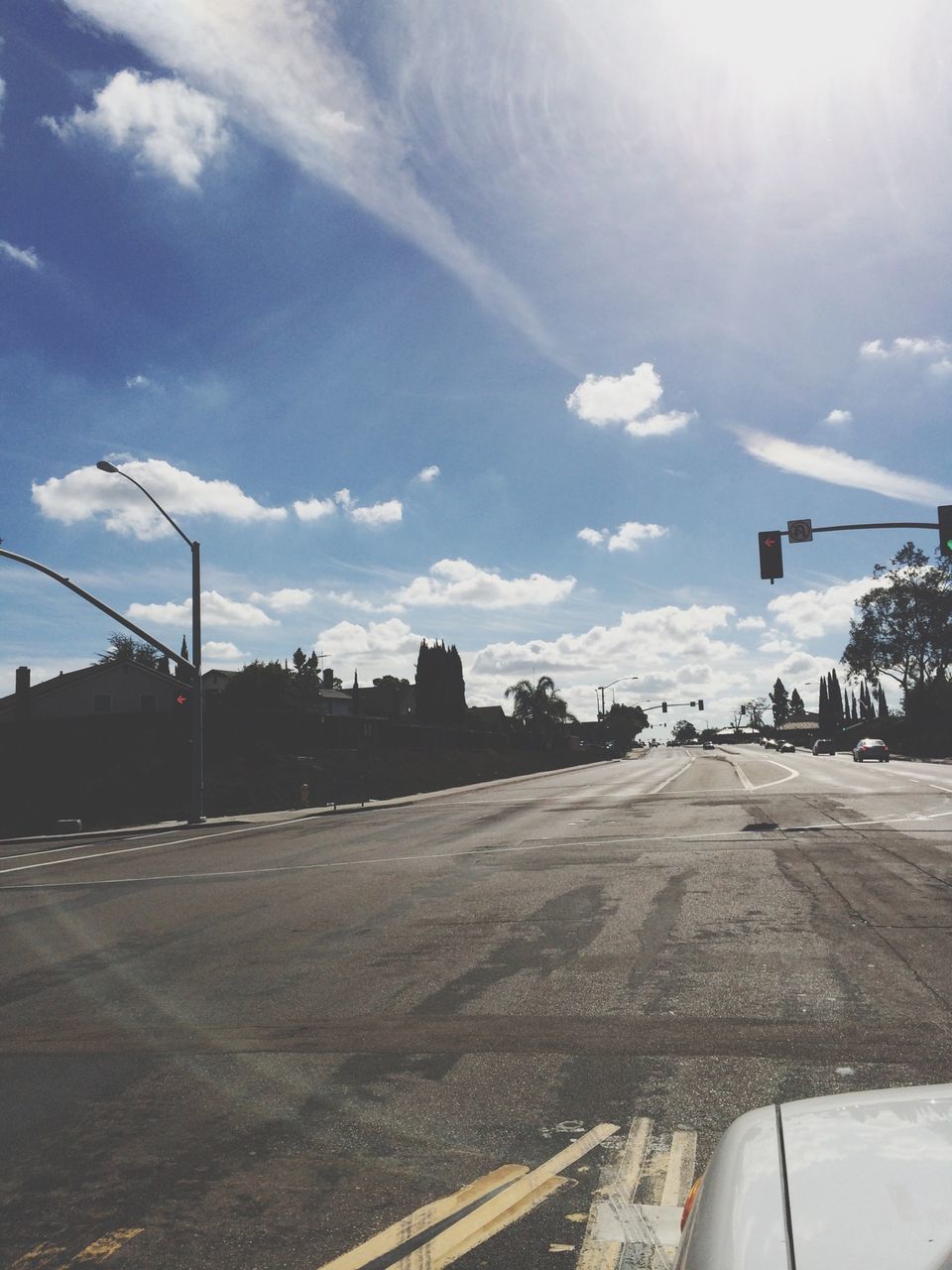 transportation, sky, road, mode of transport, car, the way forward, land vehicle, road marking, cloud - sky, sunlight, street, cloud, vanishing point, day, diminishing perspective, on the move, outdoors, sunbeam, travel, sun