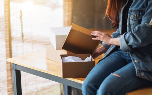 Midsection of woman holding box