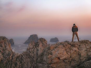 Rear view of man standing on rock