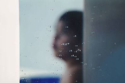 Close-up of woman looking through window