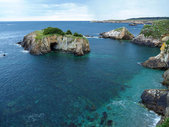 Rocks in sea against sky