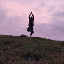 Man standing on field against sky during sunset