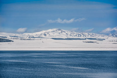 Scenic view of snowcapped mountains against blue sky