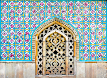 Close-up of patterned window on mosaic wall