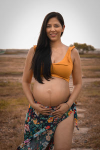 Portrait of young woman standing at beach