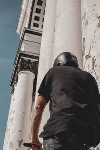 Bmx rider standing next to historical bulding