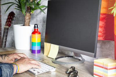 The hands of the man who works in the office with lgbt accessories.