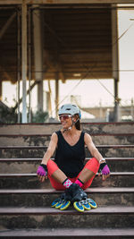 Full length of woman sitting on staircase