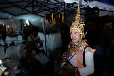 Portrait of smiling young woman in illuminated store at night