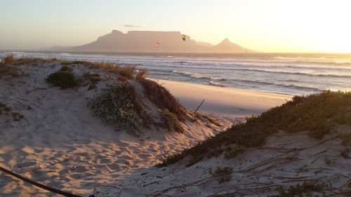 Scenic view of beach against sky during sunset