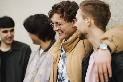 Young man laughing with arm around male friend