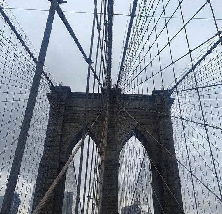 LOW ANGLE VIEW OF SUSPENSION BRIDGE IN CITY