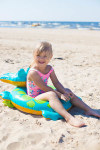 Portrait of young woman sitting at beach