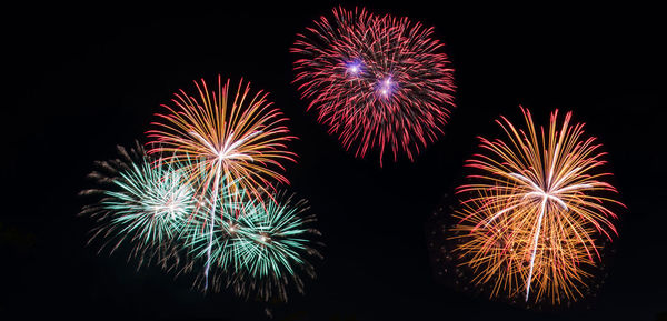 Low angle view of firework display at night