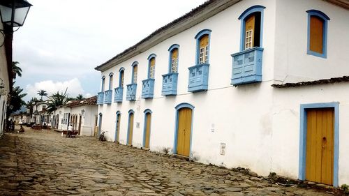 Footpath amidst buildings against sky