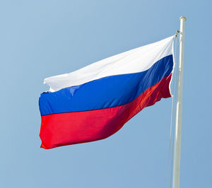 Low angle view of russian flag against clear blue sky