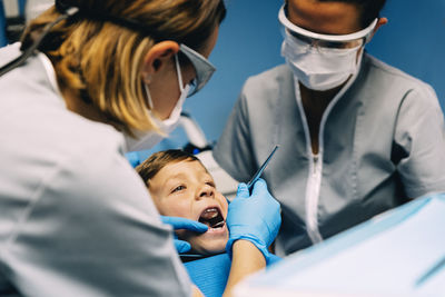 Dentist examining boy in medical clinic