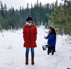 Friends standing on snow covered landscape