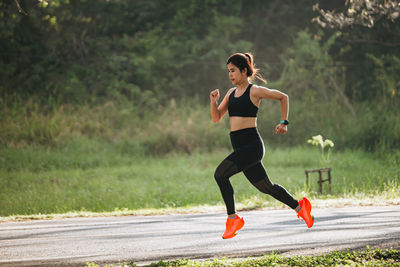 Full length of young woman exercising in park