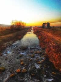 Scenic view of river against sky during sunset