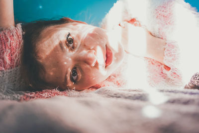 Portrait of woman lying on bed