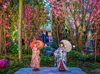 Side view of women standing by flowering plants