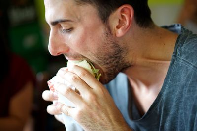 Close-up portrait of young man eating