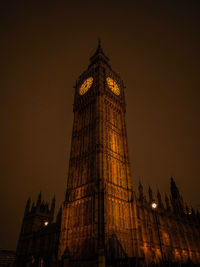 Low angle view of illuminated buildings against sky at night