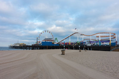 Ferris wheel at beach against sky