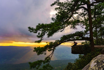 Traveler or man sitting on pha lom sak waiting sunset on phu kradueng national park,