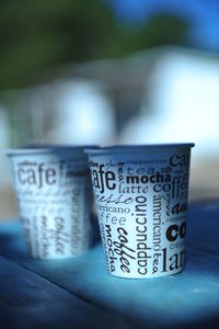 Close-up of text on disposable cups at table