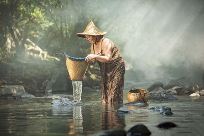 Woman holding whicker basket in river