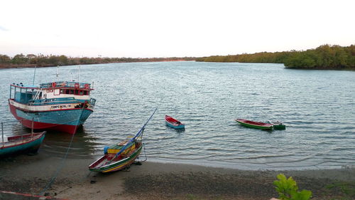 Boats moored on sea against sky