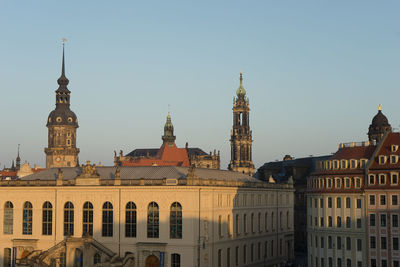 Buildings in city against clear blue sky