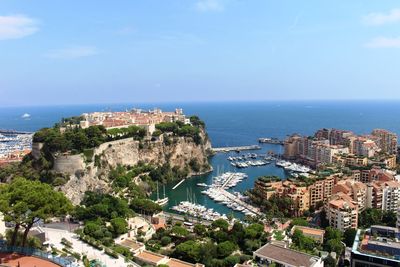 High angle view of townscape by sea against sky