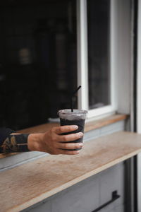 Man holding ice cream cone on table