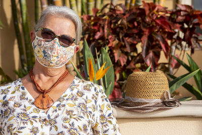 Portrait of woman wearing sunglasses by plants