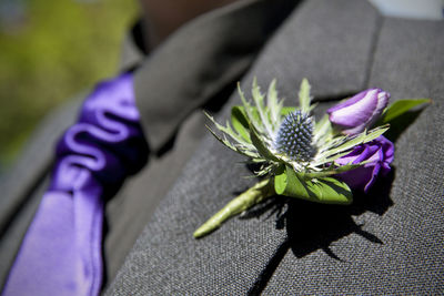 Purple flower on suit of groom