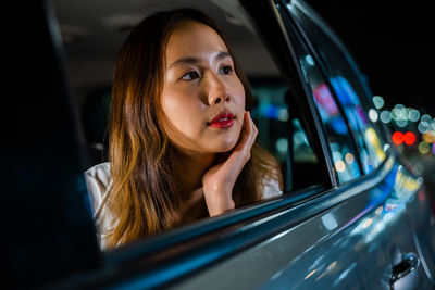Close-up of young woman reflecting on car