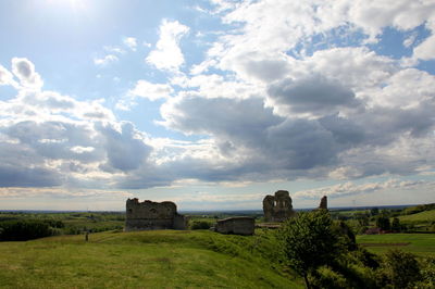 Scenic view of grassy field against cloudy sky