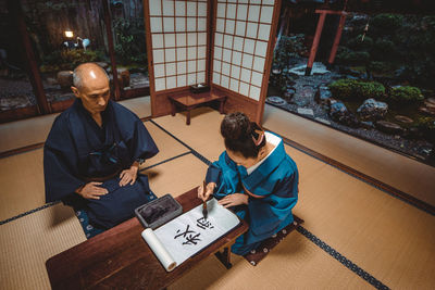 High angle view of couple sitting by table at home