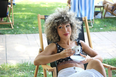 Young afro woman relaxing with a coffee