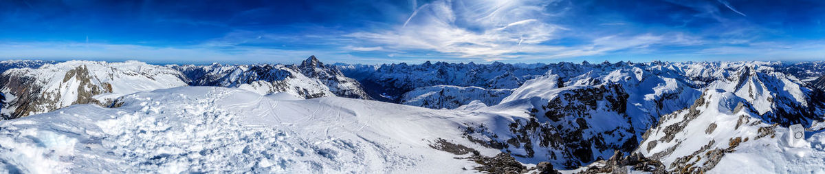 Panoramic view of snowcapped mountains against blue sky